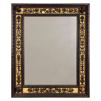 un miroir à cadre noir et doré orné d'un motif décoratif