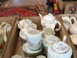 many cups and saucers in a box on the floor
