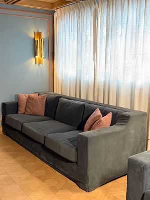 a living room with a couch, chair, and ottoman