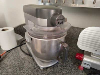 un mixeur posé sur le plan de travail d'une cuisine, à côté d'un rouleau de papier toilette