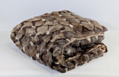 une couverture marron et blanche posée sur une surface blanche