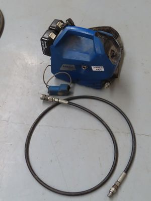 un tuyau bleu et une machine bleue posés sur une table blanche