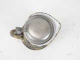 a metal cup with a metal handle on a white surface