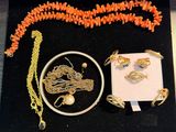 a necklace, bracelet, ring, and other jewelry displayed on a table