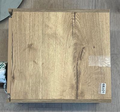 une boîte en bois sur laquelle est collée une étiquette, posée par terre