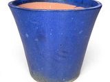 un pot bleu posé sur une surface blanche