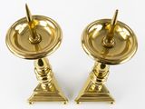pair of antique brass candlesticks on stands on a white background