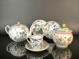quatre types différents de théières et de tasses posées sur une table