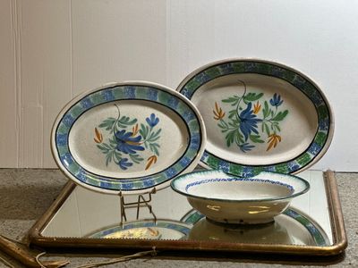 two plates and a bowl on a tray on the floor