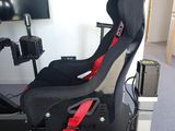 a black and red racing car seat in a room