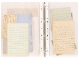 two pages of old papers and a pen on a white surface