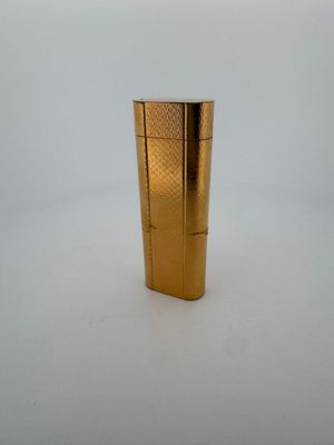 l'image d'un briquet doré posé sur une surface blanche