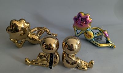 three gold figurines sitting next to each other on a table