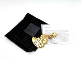 a small black bag with a gold guitar brooch on it