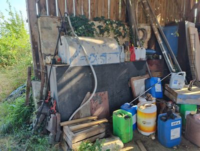 a pile of junk in a yard with a fence in the background