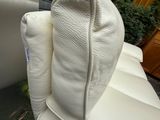 un fauteuil en cuir blanc sur lequel est posé un coussin blanc