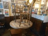 tables and chairs in a room with a clock and pictures on the wall
