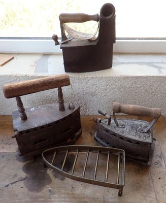 un vieux fer à repasser et une chaise en bois posés par terre