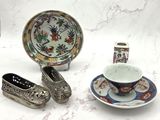 une assiette, une tasse et une soucoupe posées sur une table, à côté d'autres objets