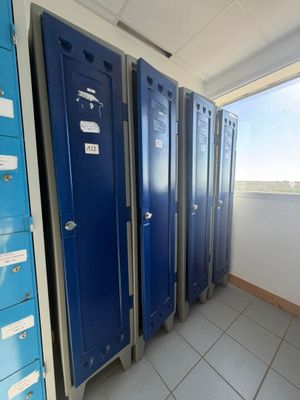 several blue lockers are lined up in a row in a room