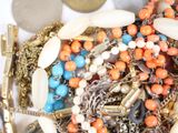 a pile of assorted necklaces and bracelets on a table