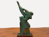 sculpture en bronze représentant un oiseau posée sur une table en bois