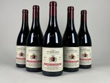 quatre bouteilles de vin sont alignées sur une table