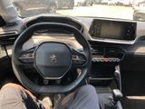 someone is sitting in the driver ' s seat of a car with their feet on the steering wheel