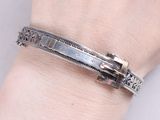 bracelet en argent orné d'une croix au poignet d'une femme