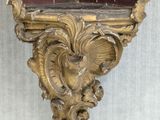 a mirror hanging on the wall with a gold frame