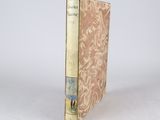 an old book sitting on top of a white table next to a white wall