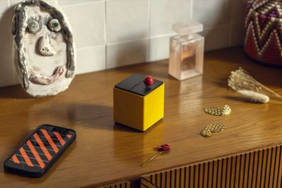 un téléphone portable posé sur une table en bois à côté d'un vase