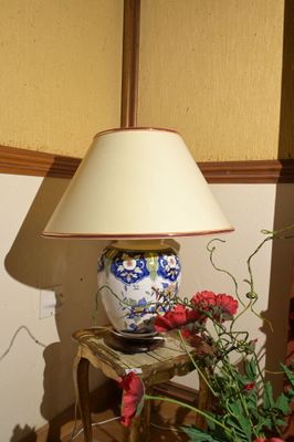 une lampe posée sur une table à côté d'un vase de fleurs