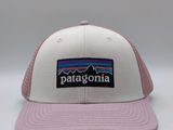 une casquette blanche et rose avec un écusson Patagonia sur le devant
