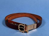 brown leather belt with a gold buckle on a blue background