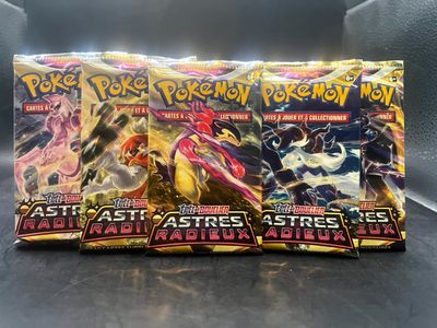 un gros plan sur trois paquets de cartes Pokémon posés sur une table