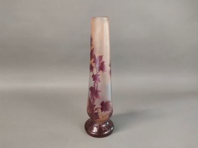 a tall glass vase with a purple flower design on it