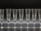 six flûtes à champagne alignées sur une surface noire