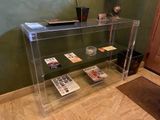 une étagère en verre sur laquelle sont posés des magazines, dans une pièce