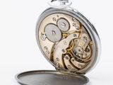 a close up of a pocket watch on a white surface