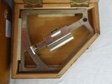 a wooden box with a metal instrument inside of it