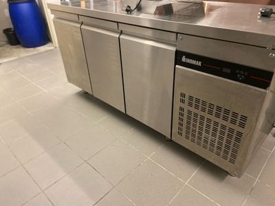 une cuisine en inox équipée d'un évier et d'un lave-vaisselle intégré au plan de travail