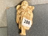 a small carved figurine of a man holding a bird