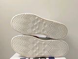 the bottom of a pair of white sneakers sitting on top of a box