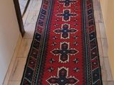 un long tapis rouge posé sur le sol dans un couloir