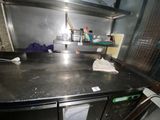 stainless steel counter top in a commercial kitchen with a lot of clutter