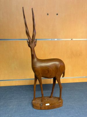 a wooden sculpture of a antelope in a room