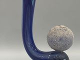 a glass sculpture of a man and a ball on top of it