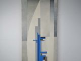 painting on the wall of a room with a chair and a table