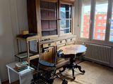 a room with a table, chair, and bookcase in it